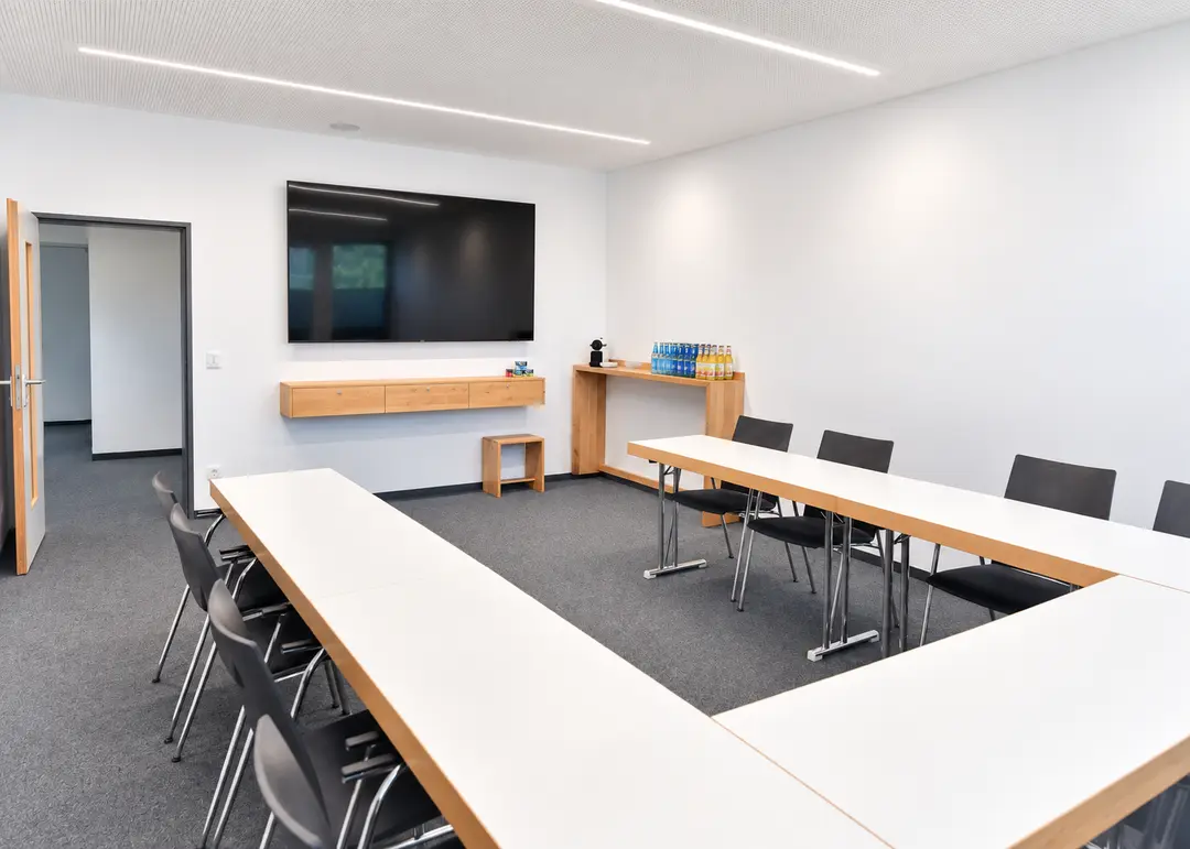 Konferenzraum der Ulm-Messe mit Tischen in U-Form, Getränken, Kaffeemaschine und TV für Meetings